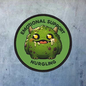 Könnte beinhalten: Ein runder grüner und schwarzer Patch mit einem Cartoon-Monster mit gelben Augen und einem breiten Grinsen. Der Text "Emotional Support Nurgling" ist um das Monster herum geschrieben.