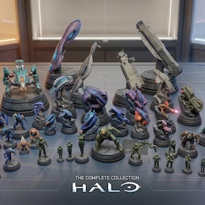 Puede incluir: Una colección de figuras detalladas de Halo, que incluyen varios personajes y vehículos, exhibidas sobre una superficie reflectante. Las figuras están pintadas en una variedad de colores y están dispuestas sobre bases circulares. El texto "THE COMPLETE COLLECTION HALO" es visible.
