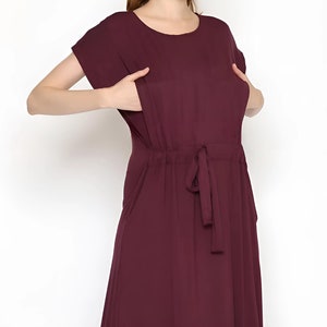 May include: A burgundy maxi dress with short sleeves and a drawstring waist.
