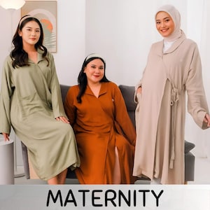 Puede incluir: Tres mujeres vistiendo kimonos de hospital de maternidad de diferentes colores. Los kimonos son de manga larga y tienen un diseño de envoltura. Las mujeres sonríen y miran a la cámara.