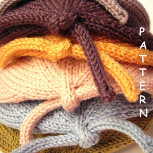 May include: A stack of five knitted hats in different colors, including brown, orange, pink, blue, and green. The hats are all tied at the top with a knot. The word "PATTERN" is visible on the right side of the image.