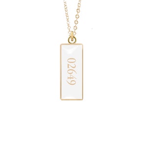 May include: A gold chain necklace with a white rectangular pendant that has the number 02649 printed on it.