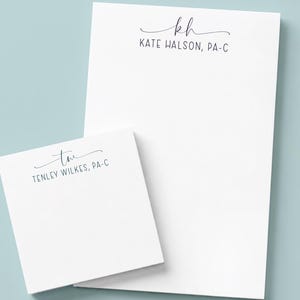 May include: A white rectangular notepad and a smaller square notepad, both featuring black printed text. The larger notepad displays the initials KH and the name KATE HALSON, PA-C. The smaller notepad displays the initials TW and the name TENLEY WILKES, PA-C.