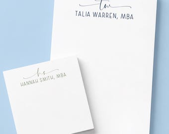 May include: A white rectangular notepad and a smaller white square notepad. The rectangular notepad features the text 'tw' in script and 'TALIA WARREN, MBA' in block letters. The square notepad features 'hs' in script and 'HANNAH SMITH, MBA'.