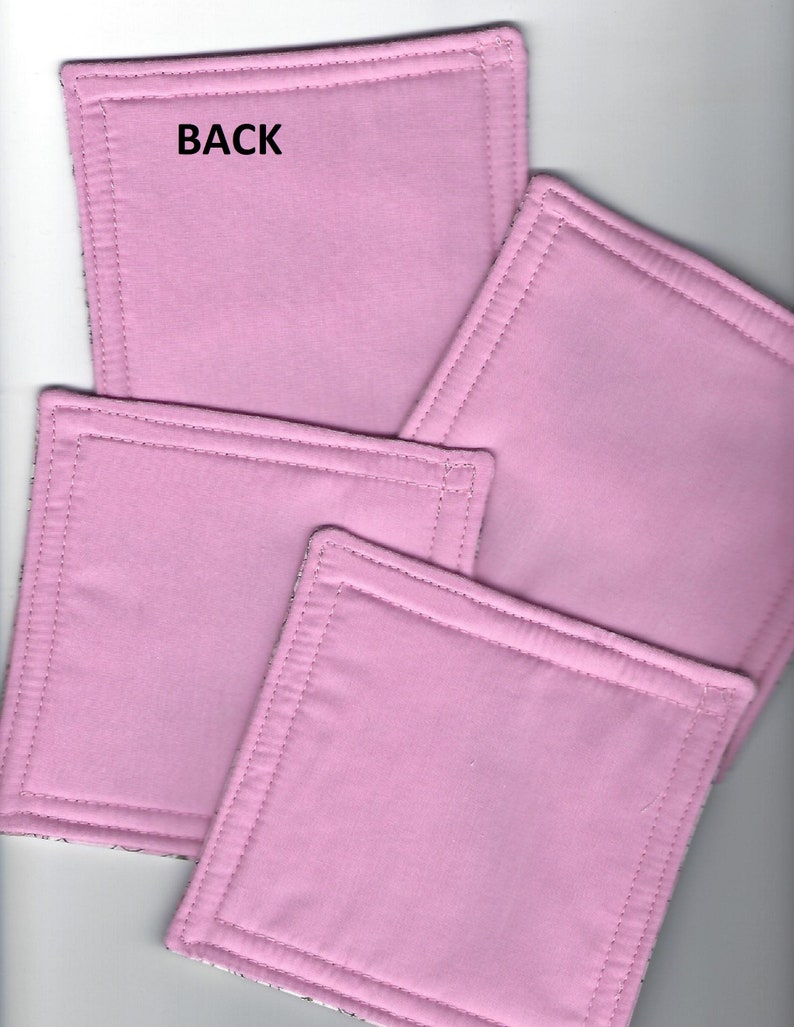 May include: Four pink fabric squares with a stitched border. The back of one square has the word "BACK" written on it.