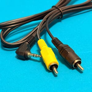 May include: Close-up of black and yellow audio-video cables against a blue background. The cables have various connectors, including a 3.5mm jack, RCA connectors, and a right-angle connector. The yellow cable is a standout feature.