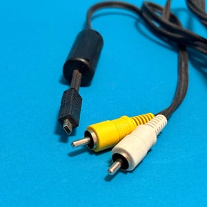 May include: Black AV cable with yellow and white RCA connectors and a black USB connector. The cable is on a bright blue background.