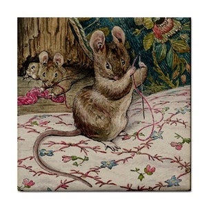 May include: A watercolor illustration of a brown mouse standing on a white fabric with a floral pattern, holding a silver needle and pink thread. Another mouse is visible in the background near a wooden structure and green foliage.