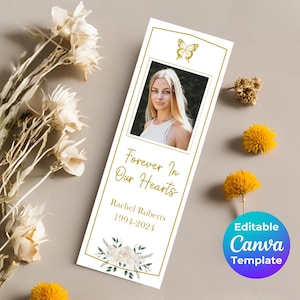 May include: White bookmark with a gold border and a photo of a woman. The bookmark has a butterfly design, white flowers, and the text "Forever In Our Hearts, Rachel Roberts, 1994-2024".