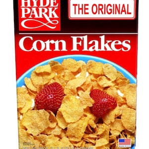Peut inclure: Boîte de Corn Flakes Hyde Park avec le texte « THE ORIGINAL » dans un encadré rouge et blanc. La boîte est rouge avec un bol bleu rempli de flocons de maïs et deux fraises. Le poids net est de 510 grammes. Fabriqué aux États-Unis.
