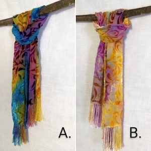 Puede incluir: Dos pañuelos de seda coloridos con flecos, uno con un patrón de degradado arcoíris y el otro con un patrón de degradado amarillo y rosa. Ambos pañuelos tienen un diseño floral.