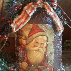 May include: A vintage-style glass jar decorated with a red and white ribbon, a sprig of greenery, and a red berry garland. The jar features a printed image of Santa Claus with the text "'Tis the Season to be Jolly".