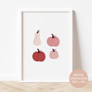 Peut inclure: Une impression d'art imprimable représentant quatre citrouilles différentes dans des tons de rose et de rouge. Les citrouilles sont disposées dans un design simple sur un fond blanc.