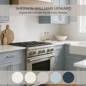 Puede incluir: Una cocina moderna con gabinetes azul claro, un horno y una estufa de acero inoxidable y una encimera blanca. La imagen incluye un fregadero de granja blanco, una ventana y una paleta de colores etiquetada como "Sherwin-Williams Upward."