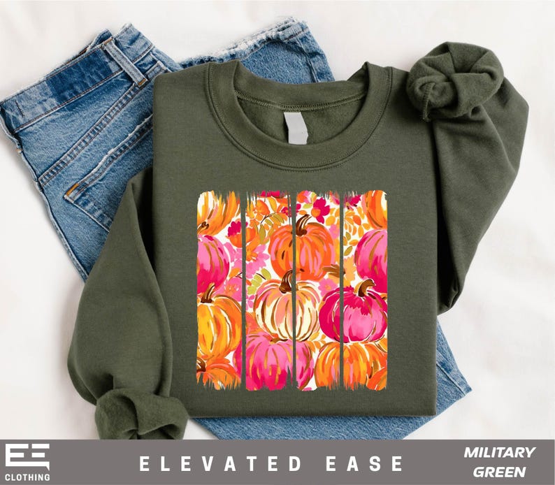 A green sweatshirt with a vibrant pumpkin graphic printed on it, along with a pair of blue jeans.