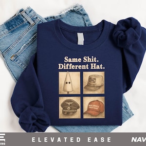May include: Navy blue sweatshirt with the text "Same Shit. Different Hat." and four images of different hats. The sweatshirt is displayed on top of a pair of blue jeans. The brand name "Elevated Ease" is printed at the bottom.