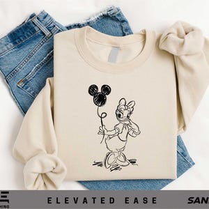 a t - shirt with a drawing of a rabbit holding a balloon