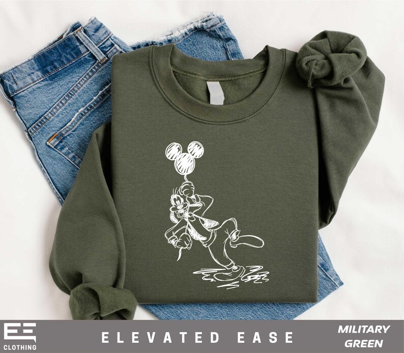 a green sweatshirt with a mickey mouse graphic on it