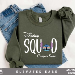 a green sweatshirt with a pair of jeans next to it
