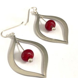 Red glass beaded silver teardrop earrings featuring sterling silver ear wire. These gorgeous, classic in style earrings feature glass beads that I made using a torch and kiln. The length of these red beaded dangle earrings is two inches.