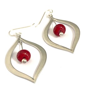Handmade earrings with sterling silver ear wire, silver teardrops and red glass beads made using a torch and kiln.