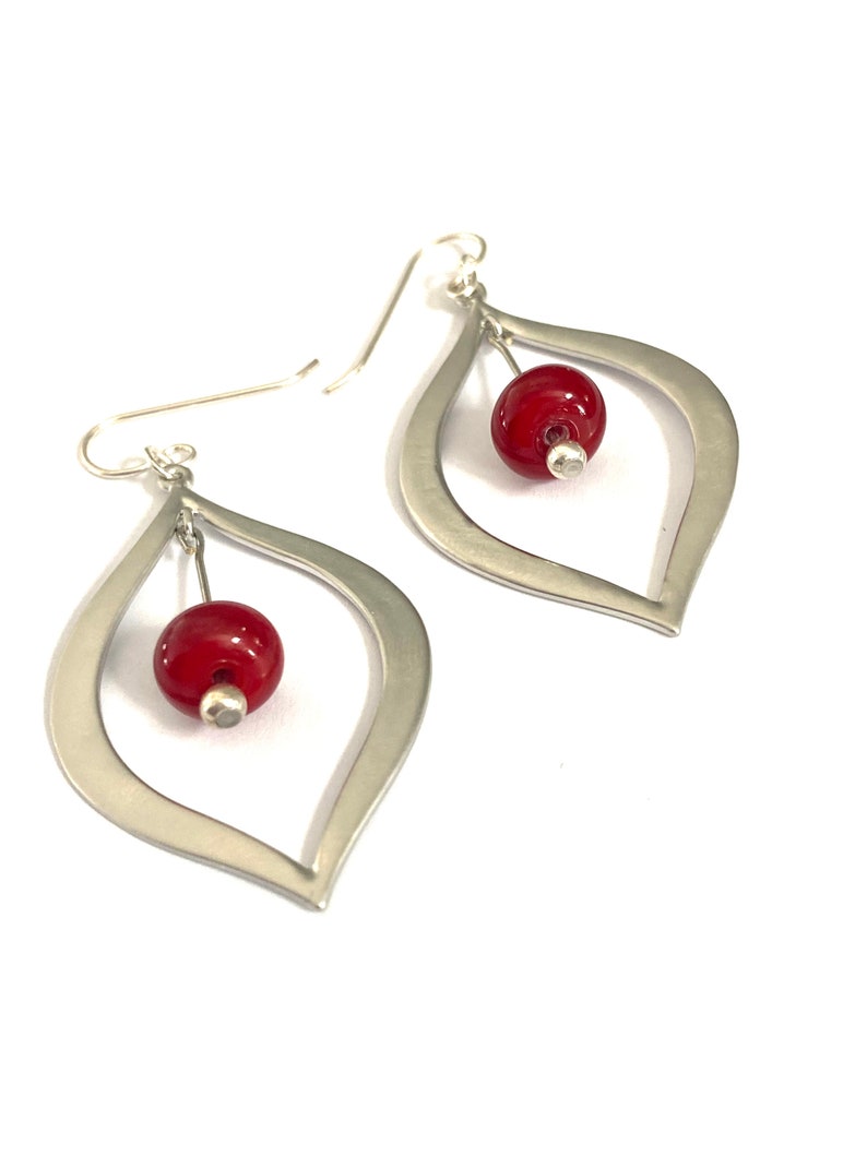 Handmade earrings with sterling silver ear wire, silver teardrops and red glass beads made using a torch and kiln.