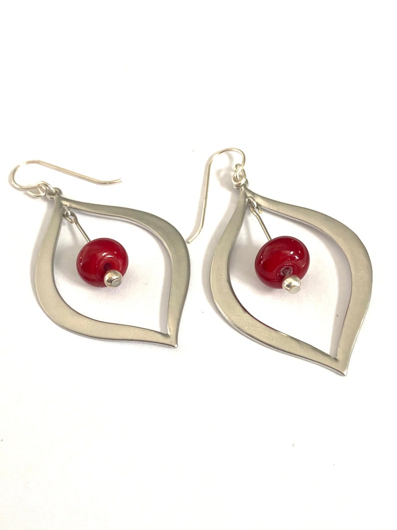 Dressy and modern red beaded earrings with silver teardrops.