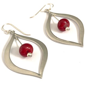 Two inch dangle earrings feature silver metal and red glass beads.