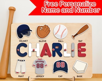 May include: A wooden baseball puzzle featuring the name "CHARLIE" in colourful letters. The puzzle includes illustrations of baseball equipment such as a helmet, glove, ball, bat, jersey, cap, pant, and base. The text "Free Personalize Name and Number" is also visible.