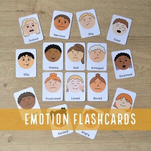 Puede incluir: Tarjetas didácticas de emociones con ilustraciones de caras que expresan diferentes emociones. Cada tarjeta muestra una emoción como "Asustado", "Feliz" y "Enojado". Las tarjetas están dispuestas sobre una superficie de madera, con el texto "EMOTION FLASHCARDS".