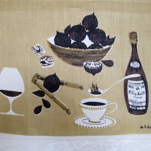 May include: A brown and white kitchen towel with a design of a bowl of nuts, a bottle of cognac, a nutcracker, a glass of wine, and a cup of coffee. The text "de Antonio R" is printed in the bottom right corner.