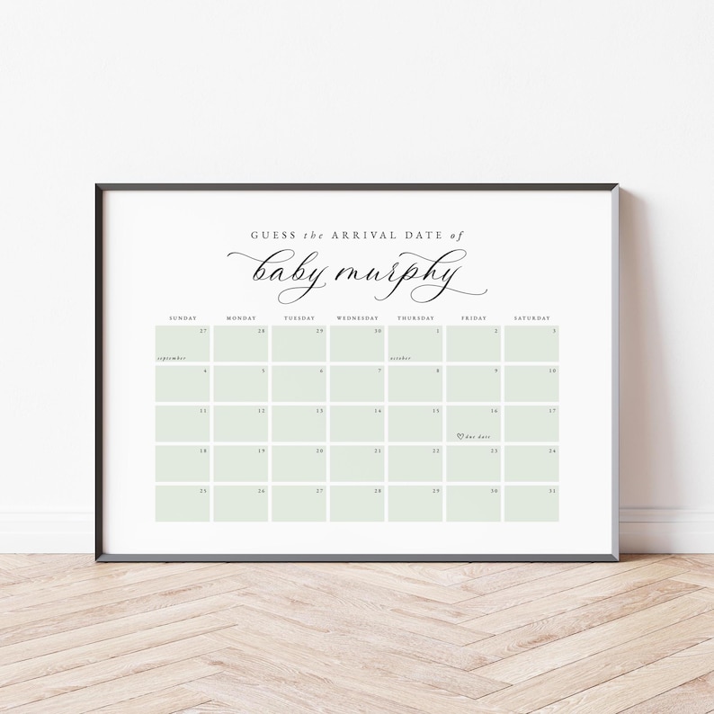 May include: A framed calendar print with the text "Guess the arrival date of baby murphy" in elegant script. The calendar grid features pale green squares and dates for September. A heart icon marks a date.
