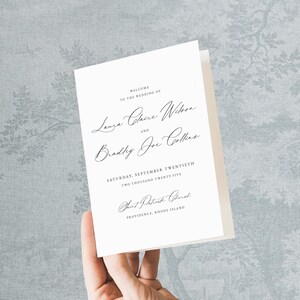 Puede incluir: Una invitación de boda blanca con letras negras. El texto dice: "Bienvenida a la boda de Laura Claire Wilson y Bradley Joe Collins". La fecha es el sábado veinte de septiembre de dos mil veinticinco. El lugar es la iglesia de San Patricio, Providence, Rhode Island.
