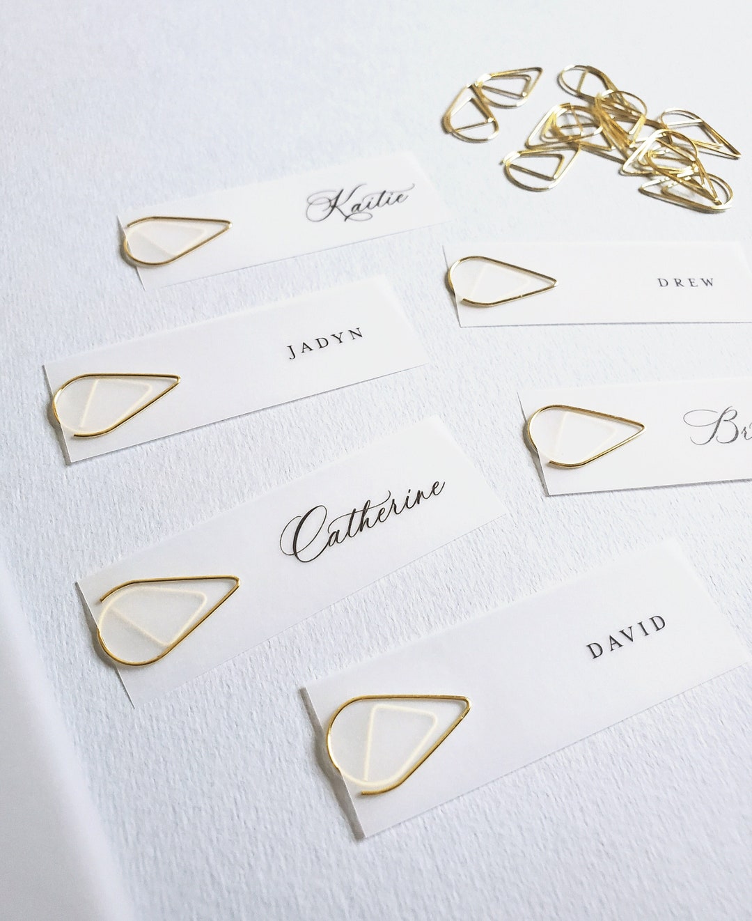 clear-wedding-menu-name-cards-and-gold-teardrop-clips-script-or-block