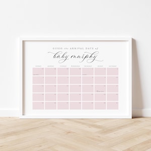 May include: A framed calendar print with the text "Guess the Arrival Date of baby murphy" in elegant script. The calendar grid is light pink, with dates from September and October. The frame is white, and the background is a light wood.