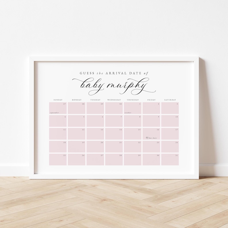 May include: A framed calendar print with the text "Guess the Arrival Date of baby murphy" in elegant script. The calendar grid is light pink, with dates from September and October. The frame is white, and the background is a light wood.