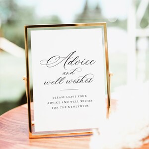 Pode incluir: Um sinal com moldura dourada e papel branco no interior. O sinal diz "Advice and well wishes" em fonte cursiva. Abaixo do texto, diz "Please leave your advice and well wishes for the newlyweds."