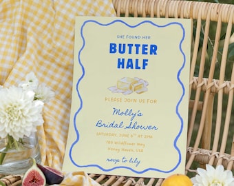 May include: A bridal shower invitation with the text "SHE FOUND HER BUTTER HALF" in blue on a light yellow background. The invitation is decorated with a blue wavy border and includes details for Molly's Bridal Shower. The scene includes fruit and flowers.