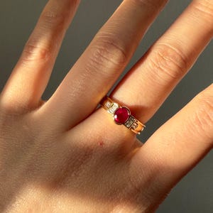 Anillo vintage de oro de 18 quilates con rubí y diamante talla esmeralda engastados en medio bisel, de inspiración Art Déco.