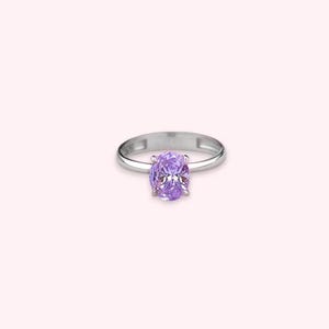 May include: A silver ring with a large oval-shaped purple gemstone.