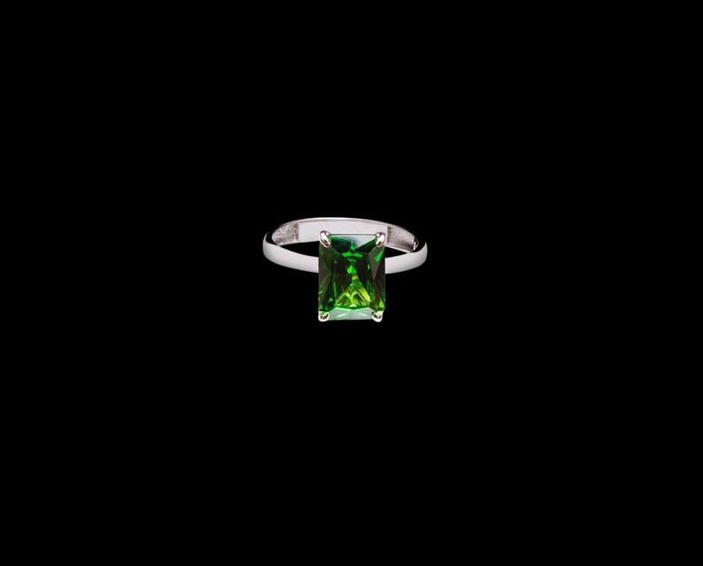 Puede incluir: Un anillo de plata con una piedra preciosa verde cuadrada.