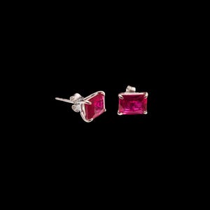 May include: A pair of stud earrings with rectangular, bright pink gemstones set in silver-colored metal. The earrings are displayed against a black background, highlighting the vibrant color and design of the jewelry.