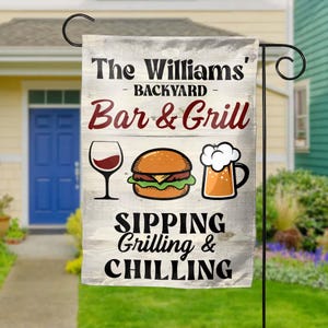 May include: A white wooden sign with the text "The Williams' Backyard Bar & Grill Sipping Grilling & Chilling". The sign features a red wine glass, a hamburger, and a glass of beer.
