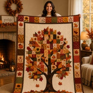 May include: A rectangular quilt featuring a central tree motif composed of patchwork squares in autumn colors including orange, red, yellow, and brown. The tree design incorporates leaf and sunflower patterns, surrounded by a cream-colored border.
