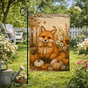 May include: A rectangular garden flag featuring a central illustration of a fox wearing a plaid bow tie, surrounded by pumpkins, sunflowers, and daisies. The scene is set against a rustic wooden fence backdrop with autumn leaves in warm tones.