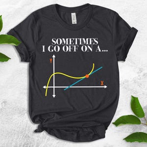 Peut inclure: Un t-shirt noir avec le texte "Sometimes I go off on a..." et un graphique avec une courbe jaune et une ligne bleue se croisant &agrave; un point rouge.