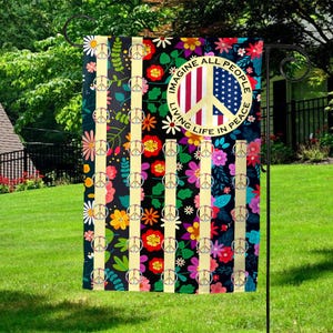 May include: A garden flag with a peace sign and the words "Imagine All People Living Life In Peace" on a black background with colorful flowers and stripes.