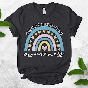 May include: A dark gray t-shirt with a rainbow design and the text "Congenital Diaphragmatic Hernia Awareness".