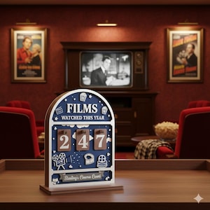 May include: A wooden film counter with the text "FILMS WATCHED THIS YEAR" and the number "247". The counter has a blue and white color scheme with film-related icons. The base of the counter reads "Starling's Cinema Count".