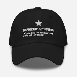 Puede incluir: Gorra de béisbol negra con texto bordado en blanco y una estrella. El texto dice "Whole day I'm fucking busy only get few money" en inglés y en caracteres chinos.